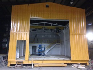 Mustard color relocatable building as seen from outside with no doors installed